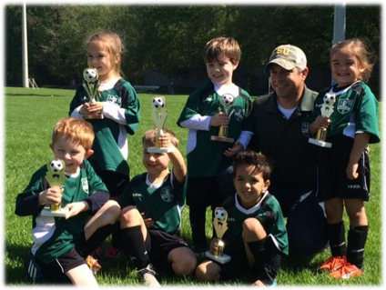 Young players from a rec team pose with their trophies